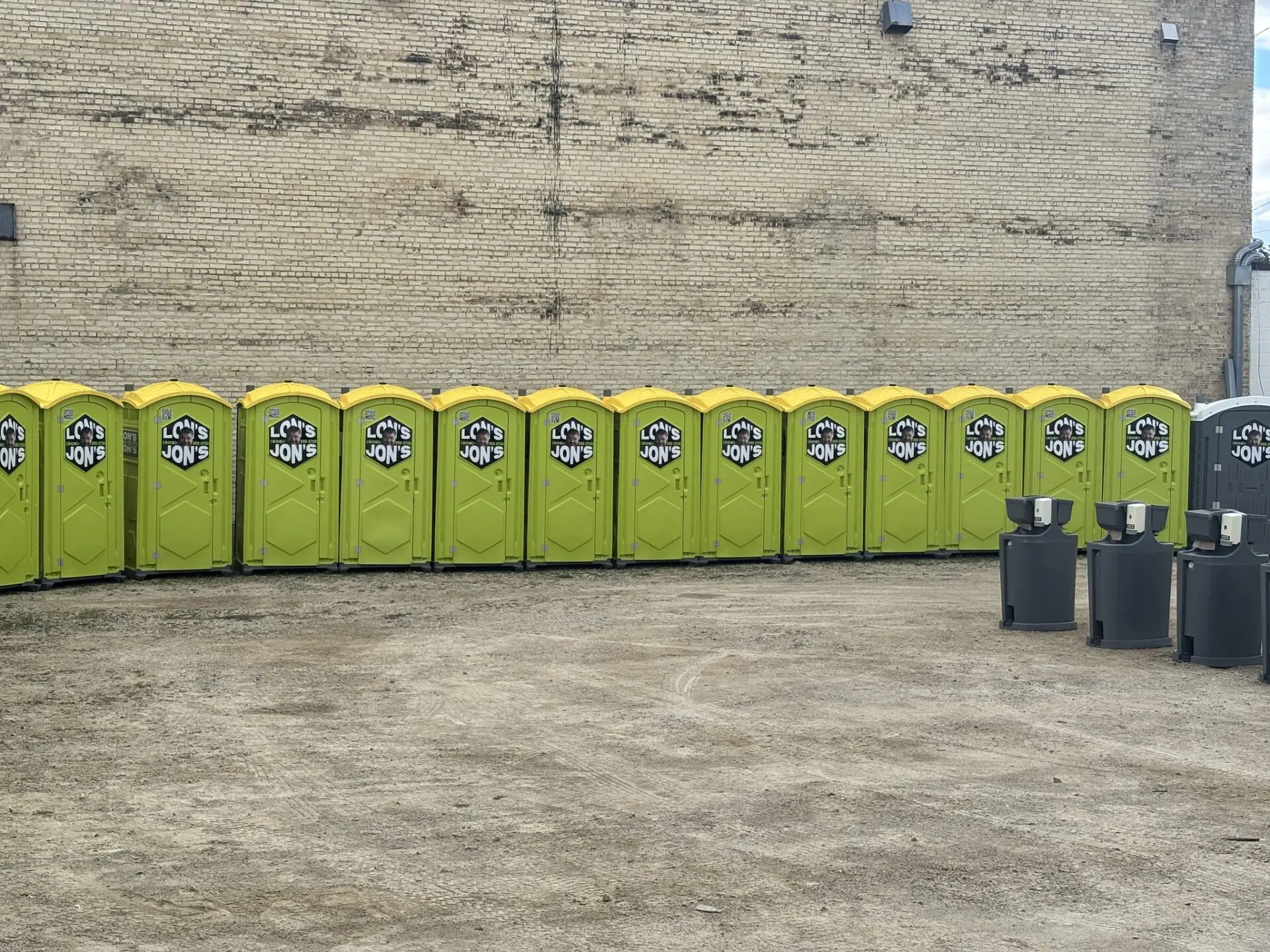 Long row of yellow porta potties and mobile sinks